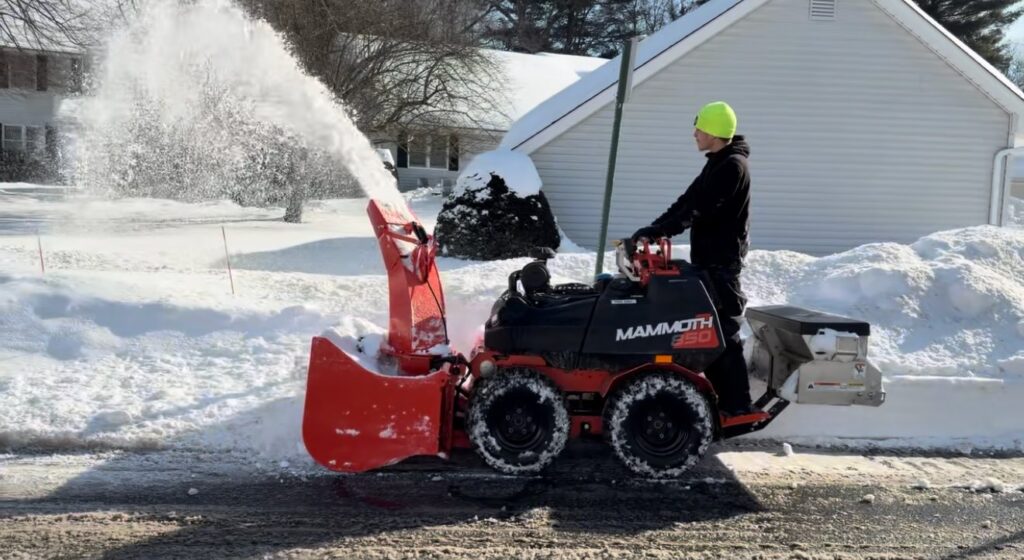 Bill's Landscaping crew clearing a sidewalk with a Mammoth 350 sidewalk snow machine and spreader